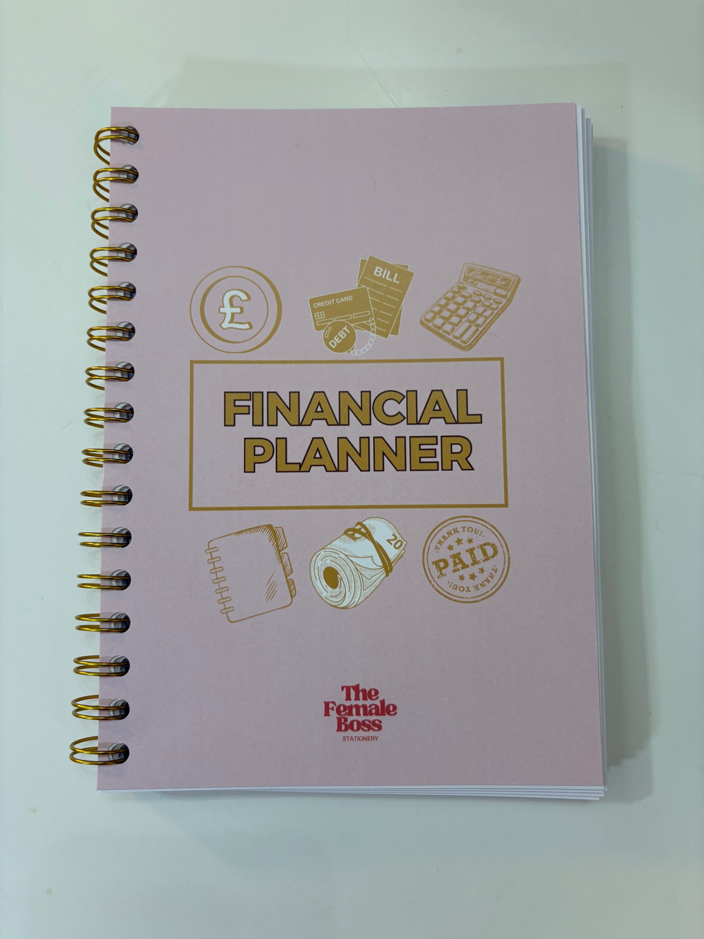 Pink financial planner with gold illustrations and text on a white background