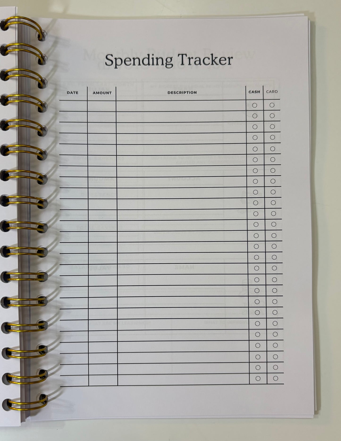 Spending tracker notebook page with columns for date, amount, description, cash, and card.