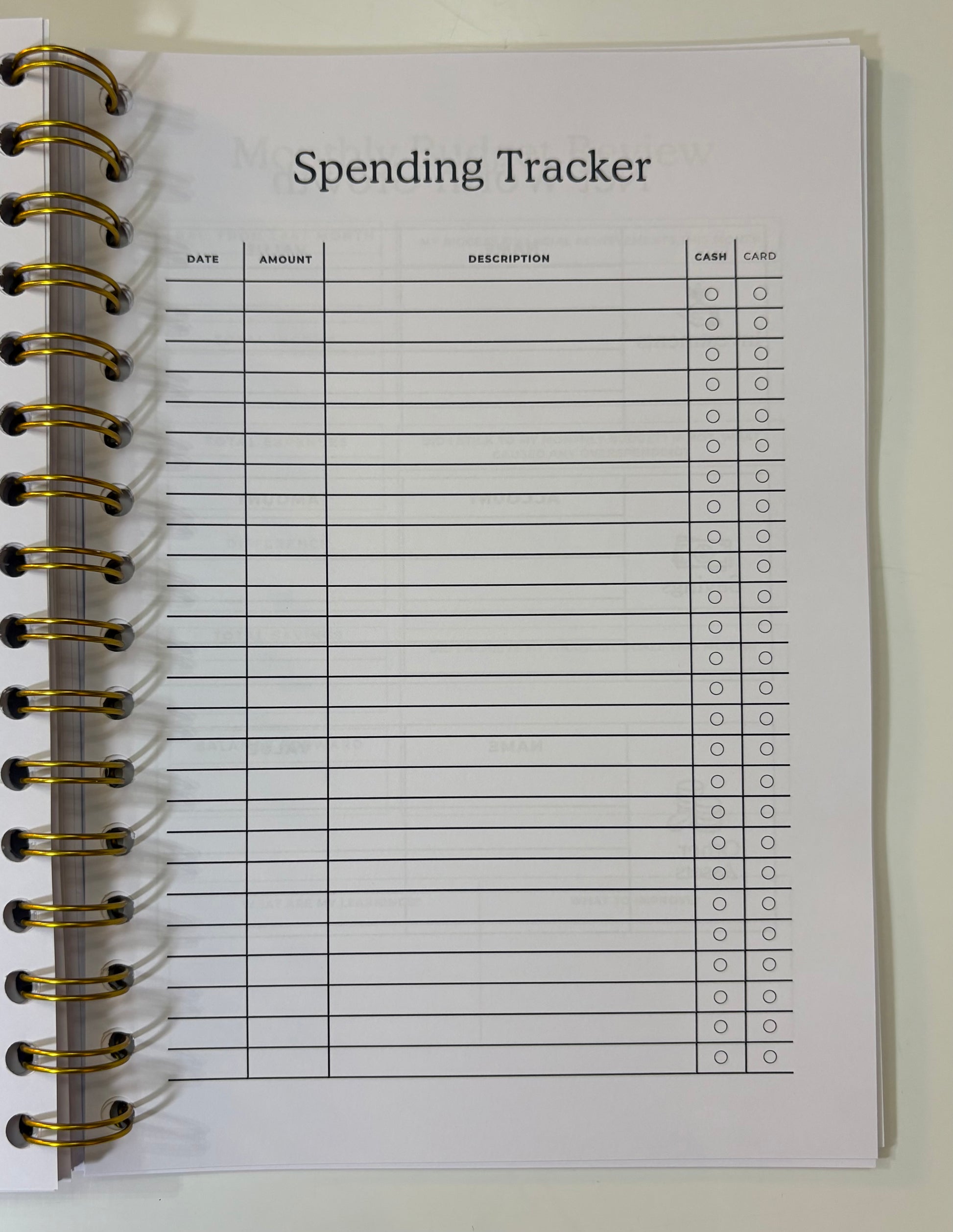 Spending tracker notebook page with columns for date, amount, description, cash, and card.